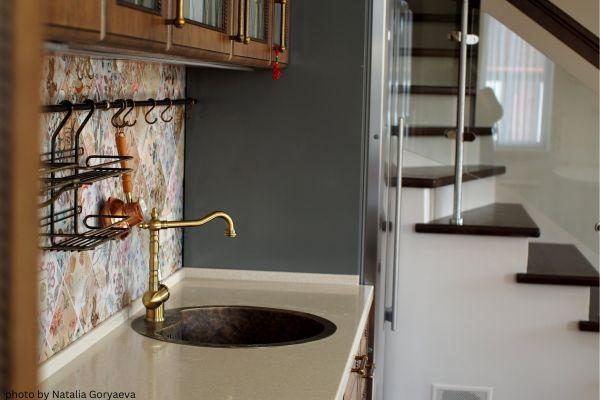 gold faucet in black and gold kitchen